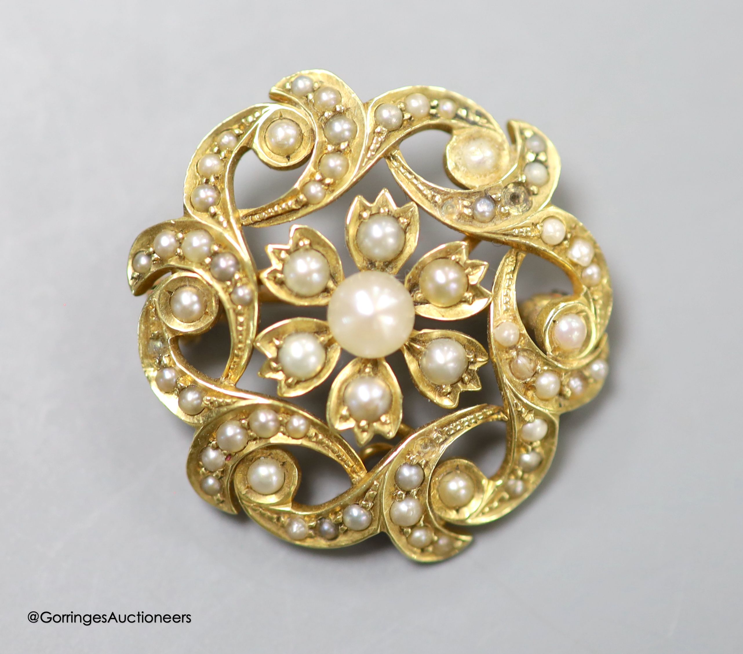 A late Victorian 15ct and seed pearl circular cluster pendant brooch, 25mm